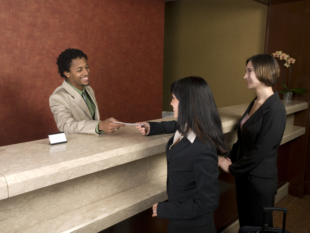Image of women checking in at a hotel registration desk
