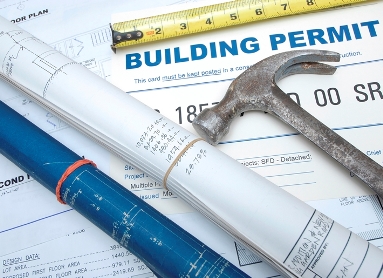 Hammer and ruler on top of a building permit document