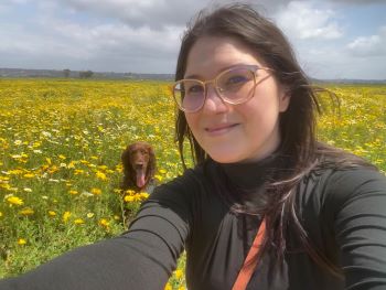 Marissa and her pet dog in a field of flowers