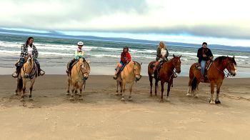 Beth with her family on horses at the beach