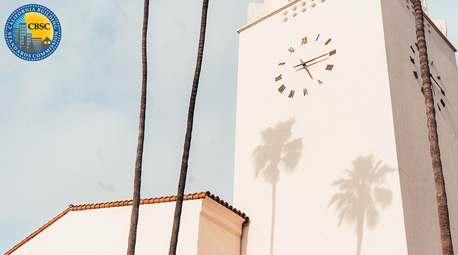 Mission tower with clock and shadows of palm trees
