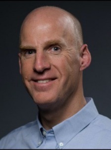 Professional headshot of Commissioner Downey