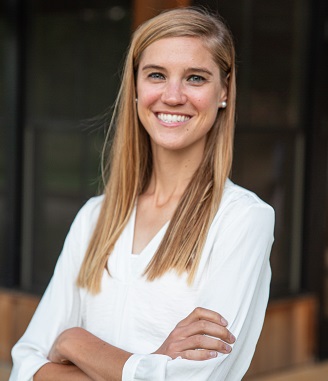 marie smiling with arms crossed wearing white blouse
