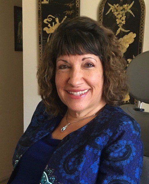 Pictured of Dr. Sue seated and smiling.