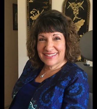 Pictured of Dr. Sue seated and smiling.