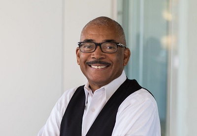 Image of Drake Dillard wearing black and white vest and black framed glasses.