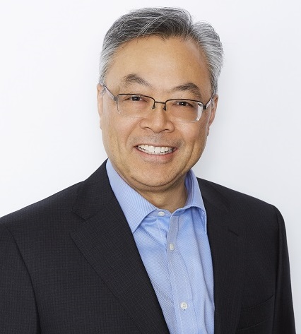 Don in blue collar shirt and black suit wearing wire glasses