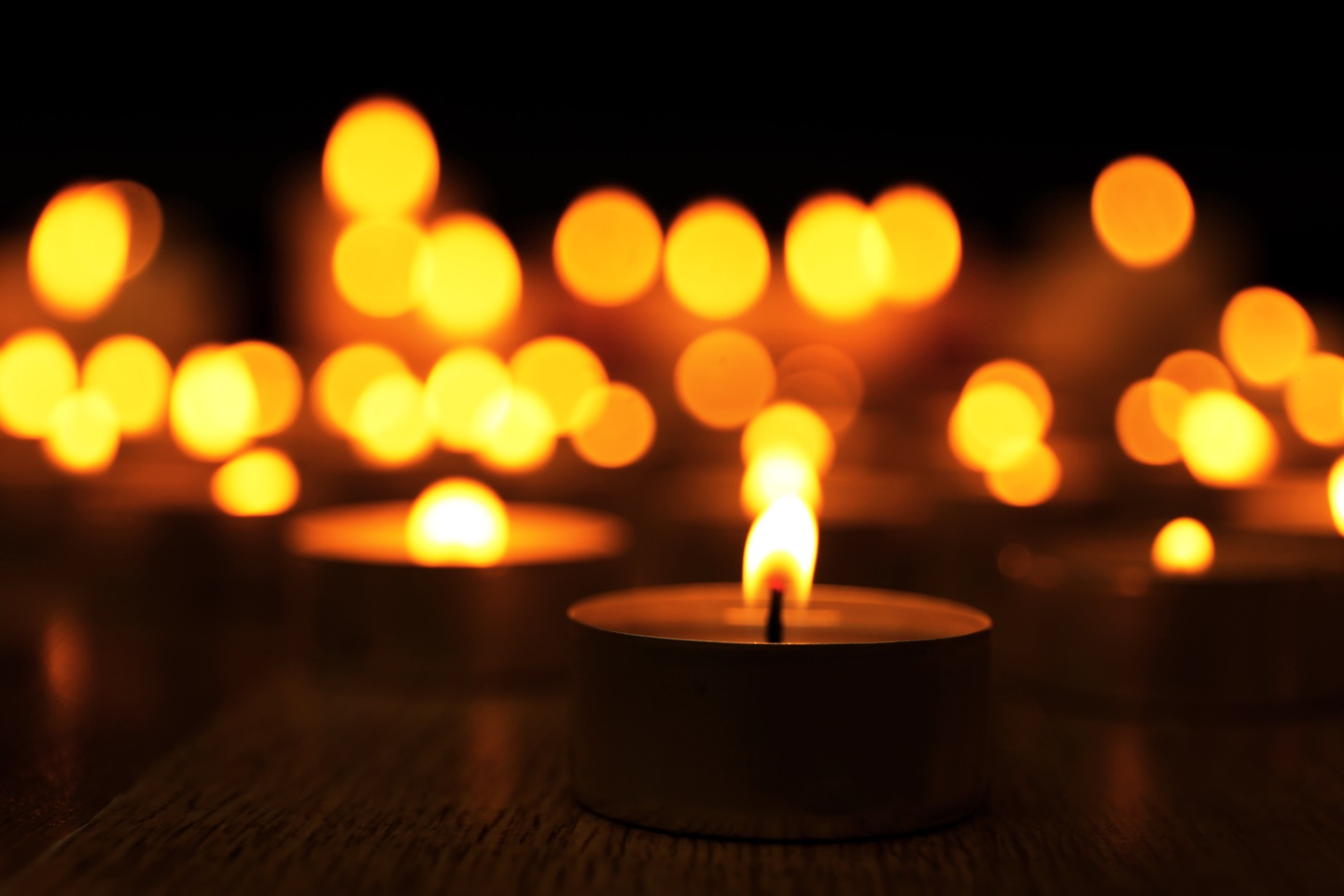 Mini candles lit in a dark background.