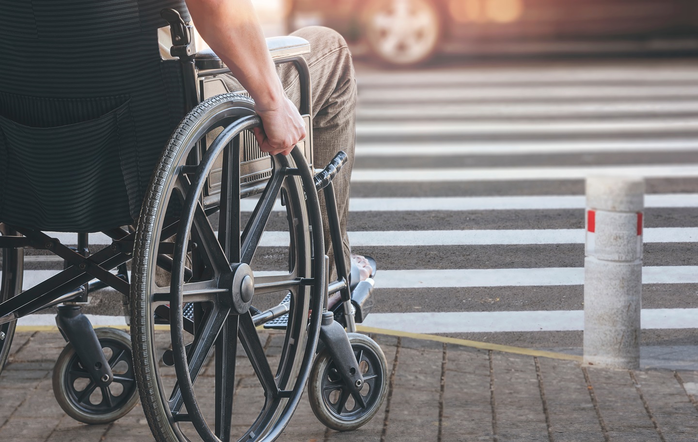Picture of a wheelchair user at the beginning of a crosswalk