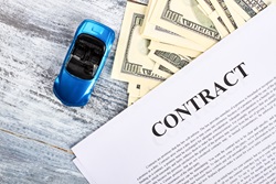 model car on desk with paper money and contract