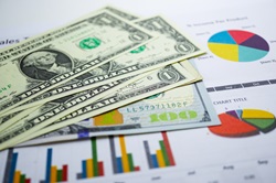 image of paper money on top of pie charts and graph chart