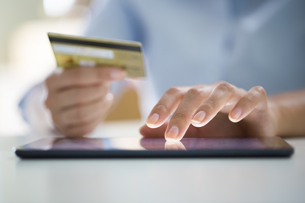 person holding credit card ordering on a tablet