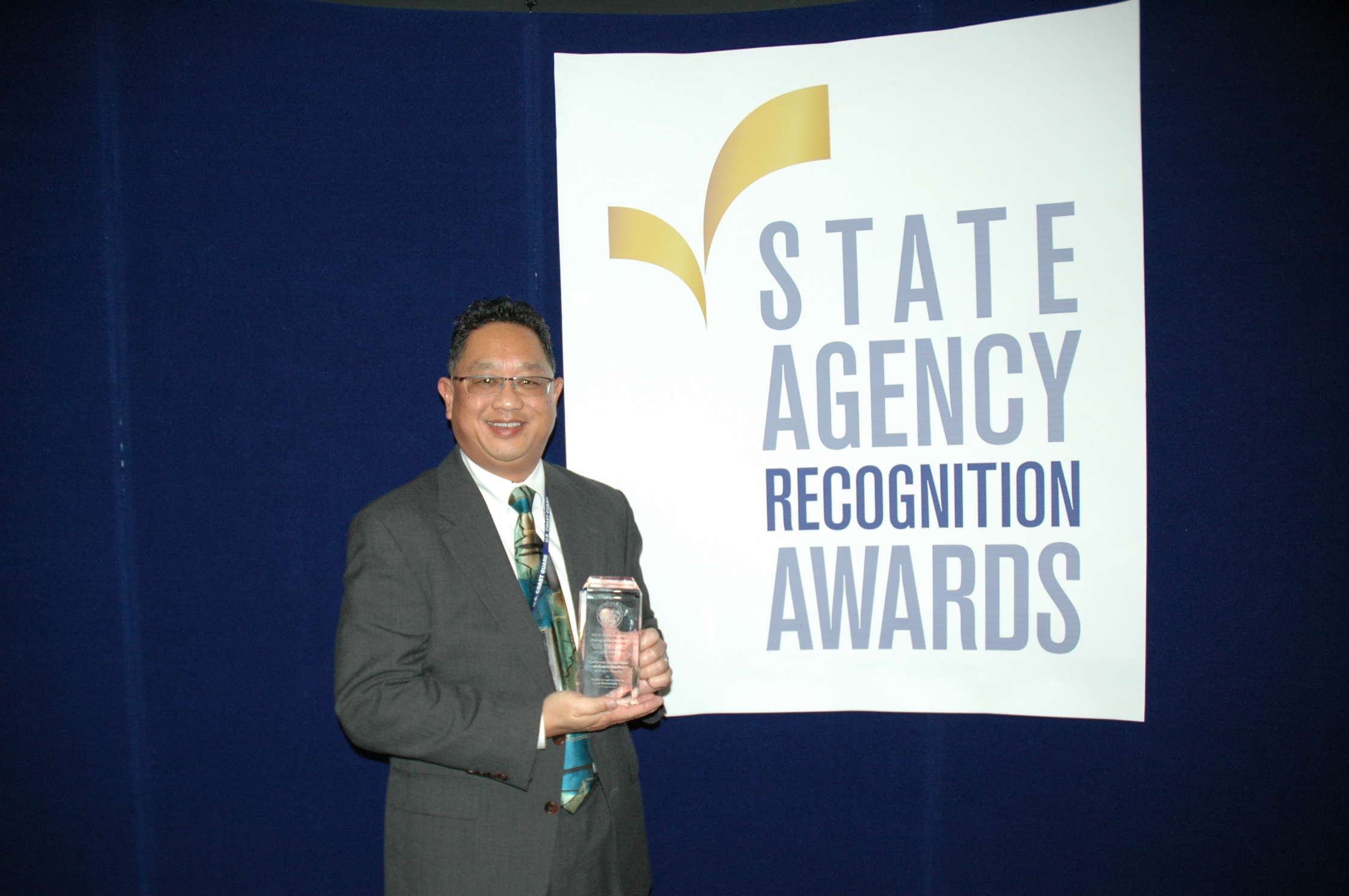 Alan Lum accepts the most improved small business participation award for the California department of public health for the extra large agency category