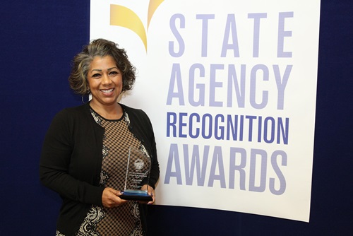 Andrea Pina, Department of Consumer Affairs, accepts the Silver Advocate of the year award.