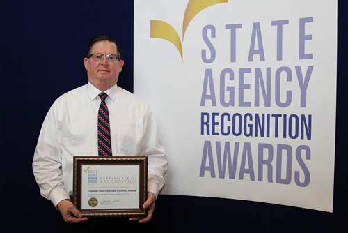Duane Johnson accepts the most improved small business participation award for the California State Polytechnic University, Pomona for the extra large agency category.