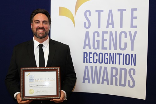 Ryan Boyd accepts the most improved small business participation award for the Employment Training Panel for the small agency category