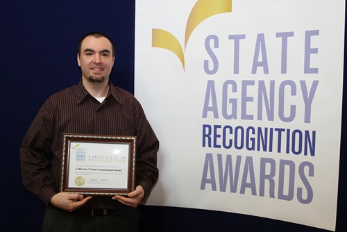 Ryan Metzer accepts the most improved DVBE participation award for the California Victim Compensation Board for the medium agency category