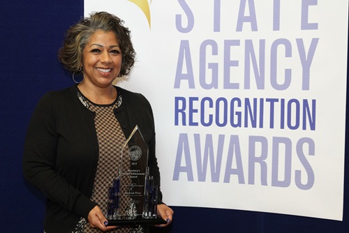 Andrea Pina, Department of Consumer Affairs, accepts the Secretary's special achievement award