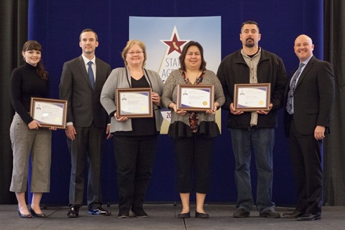 A group photo of all the most improved disabled veteran business enterprise participation winners with the presenter, Russell Atterberry.