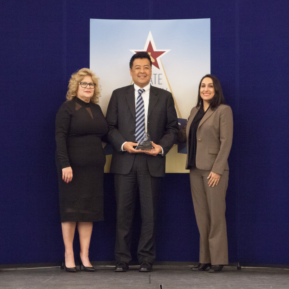 Nina Martinez and David Fong accept the Governor's Award for the California Department of Corrections and Rehabilitation Headquarters, Presented by Maral Farsi, Deputy Director of Legislative and Inter-Governmental Affairs, Governor's Office of Business and Economic Development.