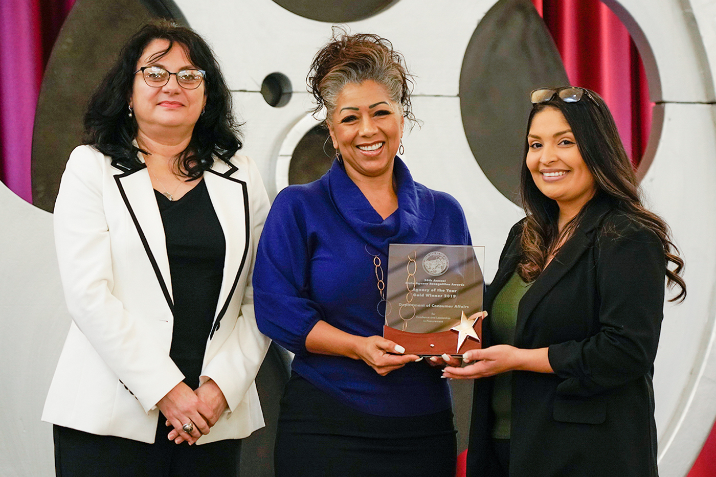 Anda Draghici, Department of General Services, presents the Department of Consumer Affairs with the Gold Agency of the Year award.