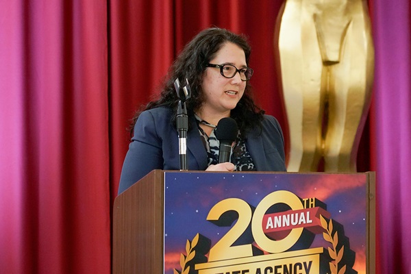 Isabel Guzman, Director of the Office of the Small Business Advocate at the Governor's Office of Business and Economic Development, presents the Governor's Award to the Office of Statewide Health Planning and Development. They could not attend to accept the award.