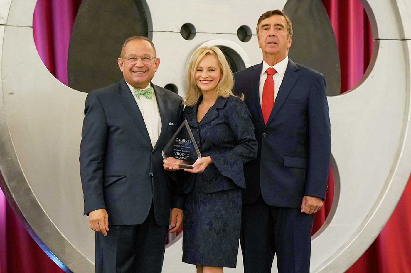 Vito Imbasciani, Secretary of the California Department of Veterans Affairs presents the Veterans Business Outreach Center, Region IX, with the John K. Lopez award for Business Excellence. Coreena Conley, President and CEO, and Robert Beamer, Chairman of the Board, accept the award.