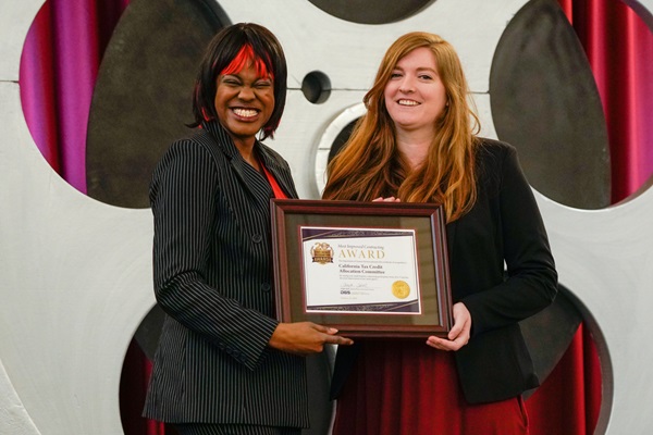 Demeshia Swanson, Department of General Services, presents the California Tax Credit Allocation Committee with the award for Most Improved Small Business Contracting for a small agency.