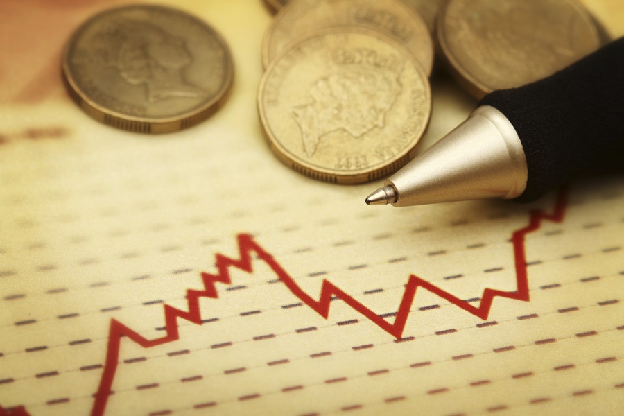 Photo of a chart, pen and coins